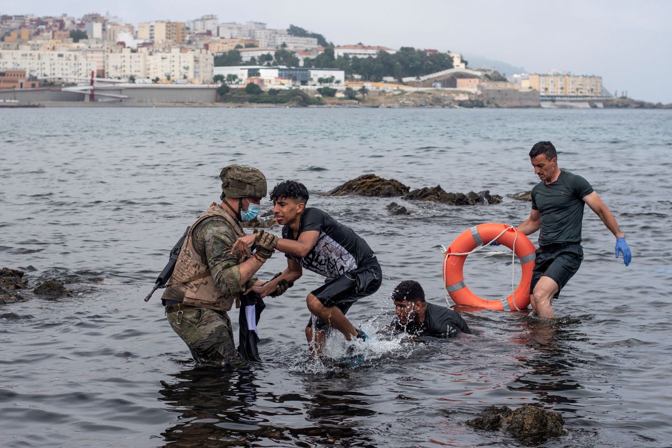 Soldados españoles ayudan a inmigrantes en Ceuta. (EFE)