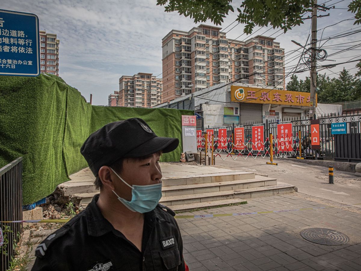 Foto: Personal de seguridad a la entrada del mercado Yuquandong, en Pekín. (EFE)