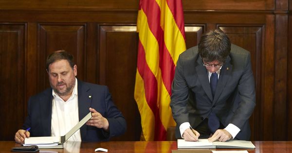 Foto: El presidente de la Generalitat, Carles Puigdemont (d), acompañado por el vicepresidente, Oriol Junqueras, firma la convocatoria de referéndum. (EFE)