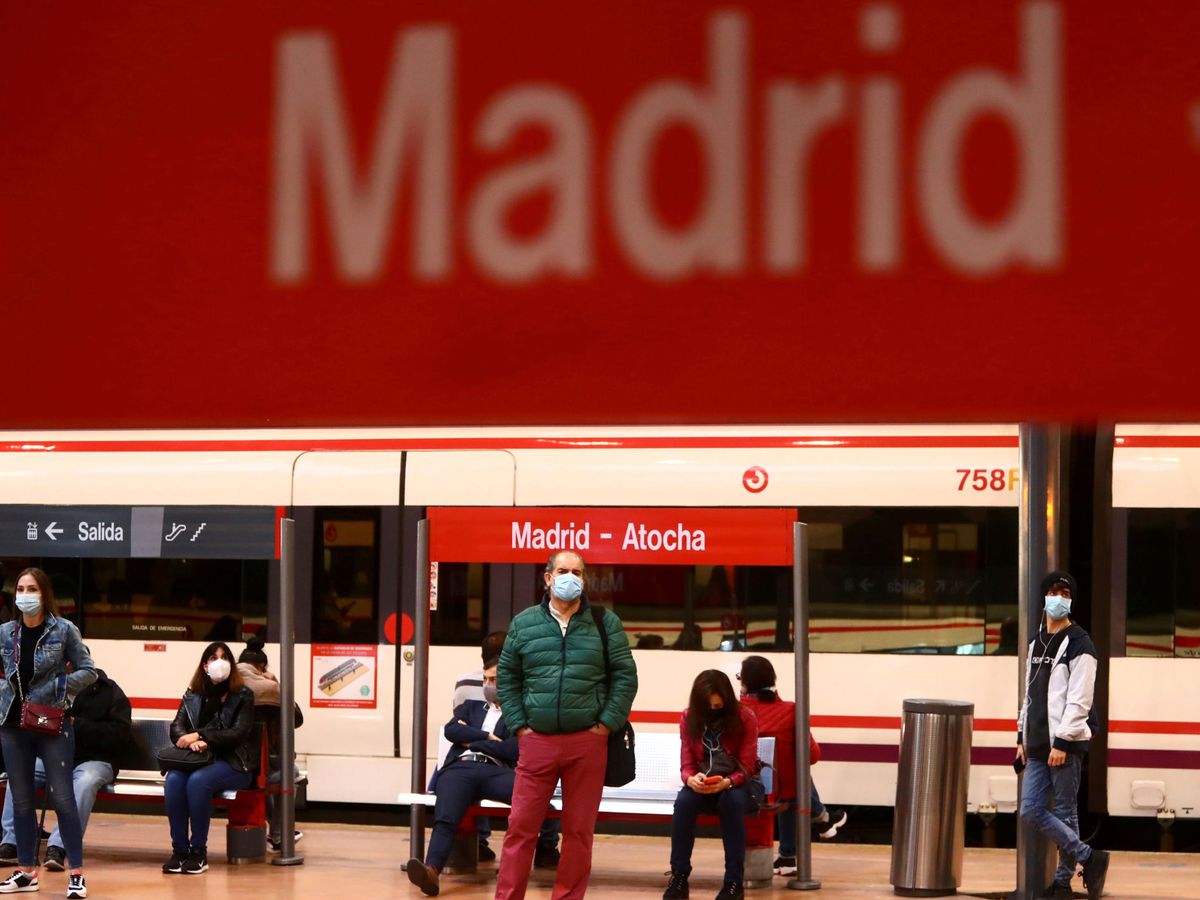 Foto: Personas con mascarilla esperan el tren en la estación de Atocha. (EFE)