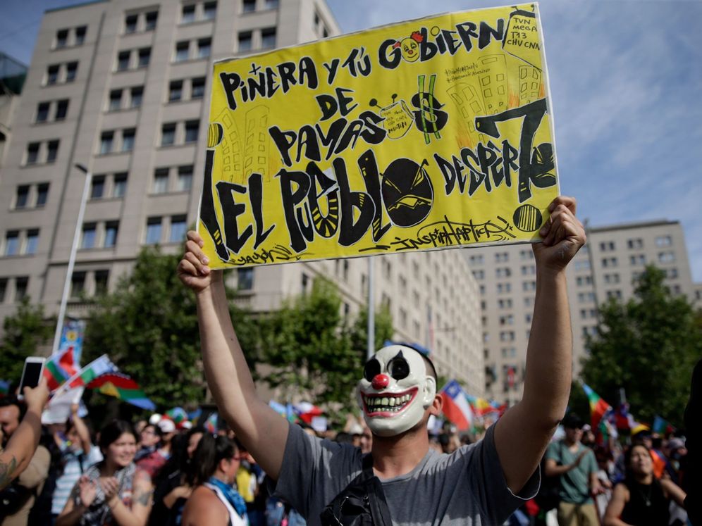 Foto: Un manifestante muestra un cartel contra el presidente Sebastián Piñera durante una protesta frente al Palacio de La Moneda, en Santiago (Chile).(EFE)