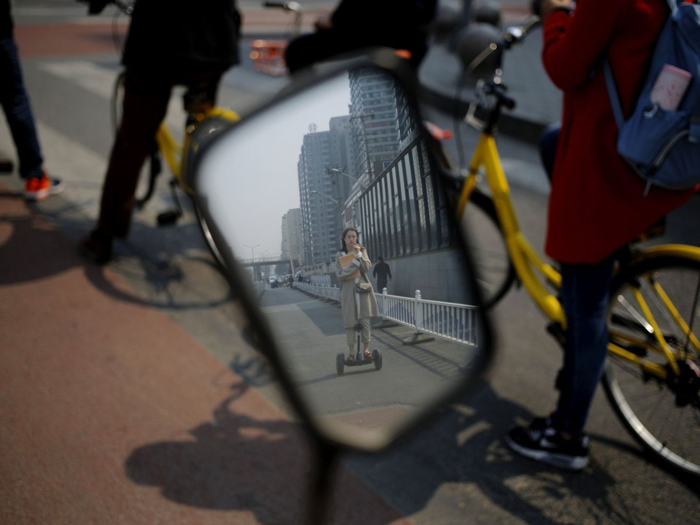 Una ciudadana china que se desplaza en un patinete eléctrico en Pekín | EFE