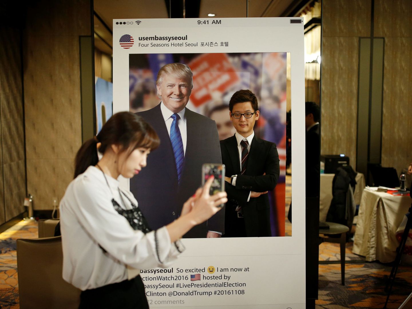 Una mujer surcoreana hace una fotografía de su acompañante junto a una figura de Donald Trump durante un evento organizado por la embajada de EEUU en Seúl el día de las elecciones estadounidenses. (Reuters) 
