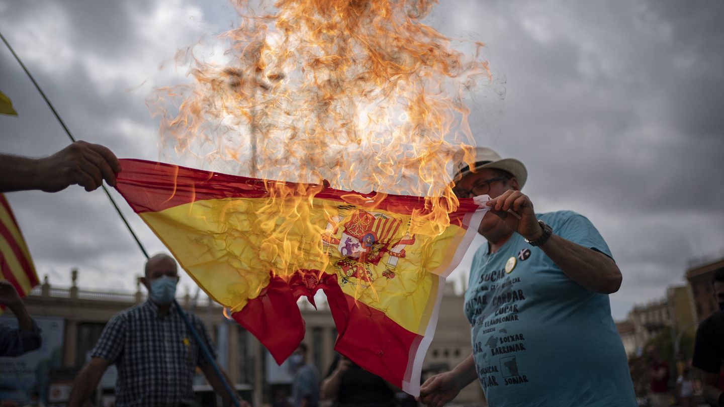 Un manifestante independentista quema una bandera de España. (Joan Mateu Parra)