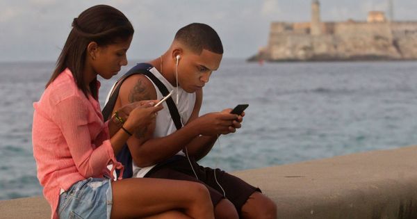 Foto: Jóvenes se conectan a internet en el malecón de La Habana. (EFE)