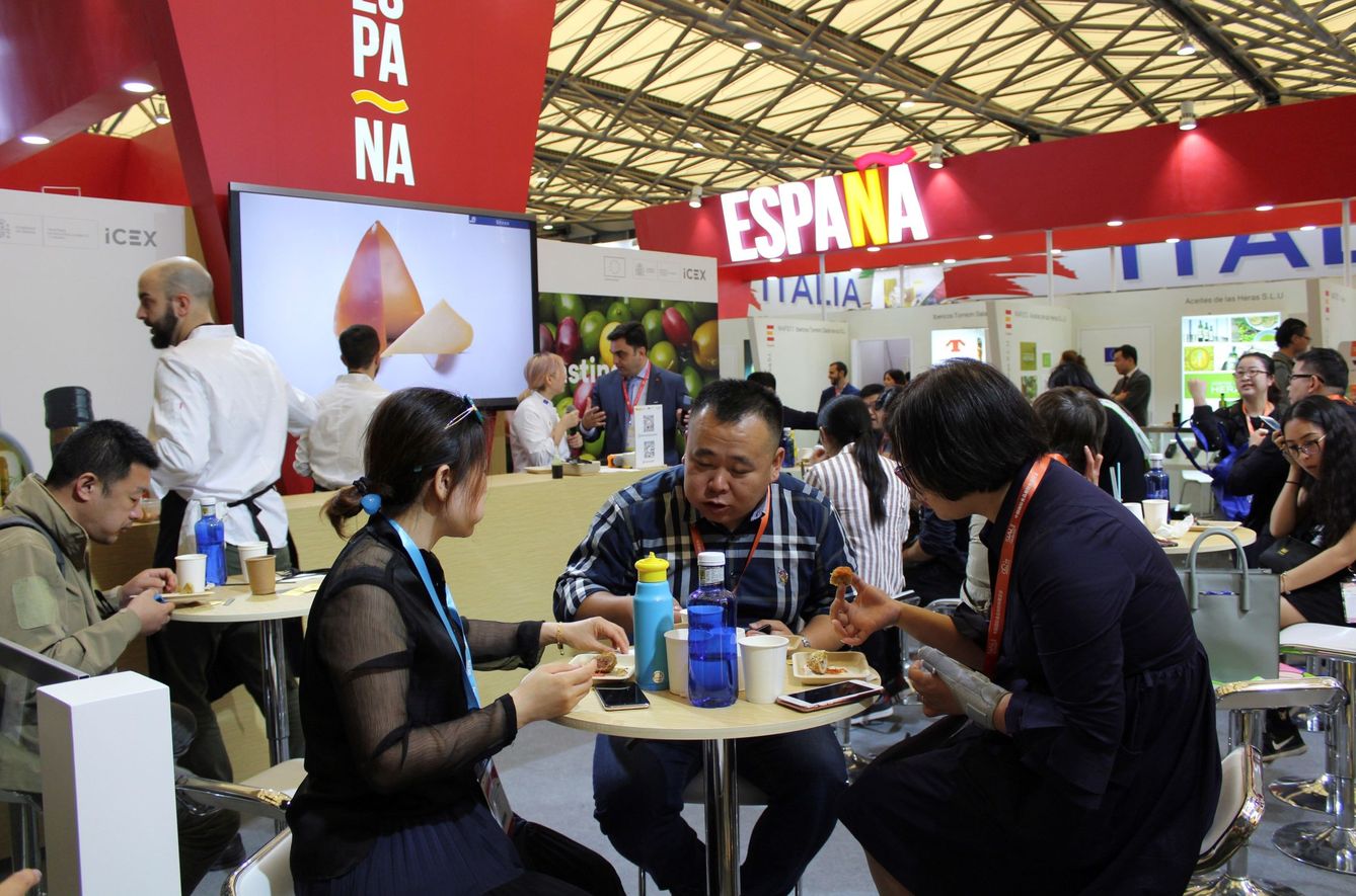 Varias personas visitan el stand de España en la Feria Agroalimentaria Internacional SIAL 2019, en Shangái, China. (EFE)