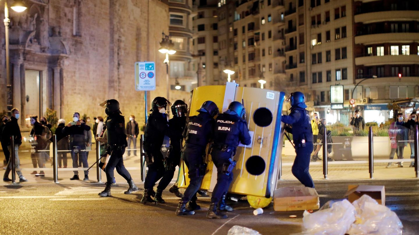 Varios policías nacionales despejan una calle durante la concentración en apoyo a Pablo Hasél, en Valencia. (EFE)