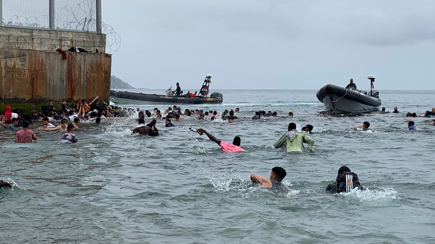 Un grupo de personas tratan de llegar a nado desde la playa de la localidad de Fnideq (Castillejos, Marruecos) hacia uno de los espigones de Ceuta. (EFE)