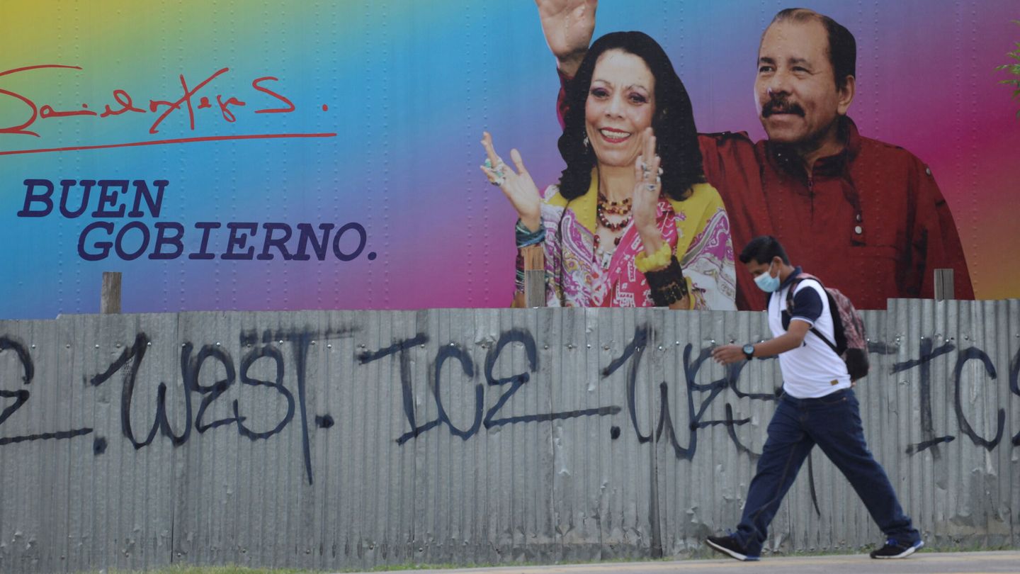 Un hombre camina frente a una pancarta en la que aparecen Rosario Murillo y Daniel Ortega. (Reuters)