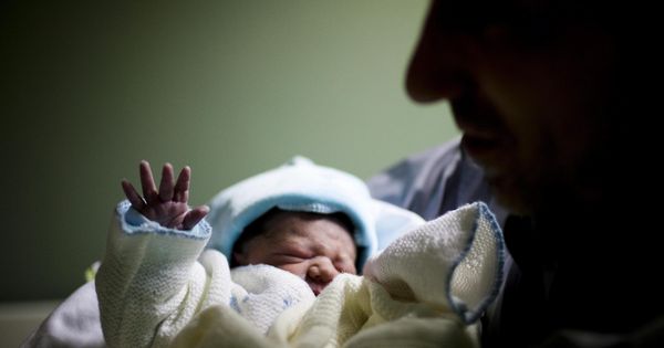 Foto: Un recién nacido en brazos de su padre (Efe)