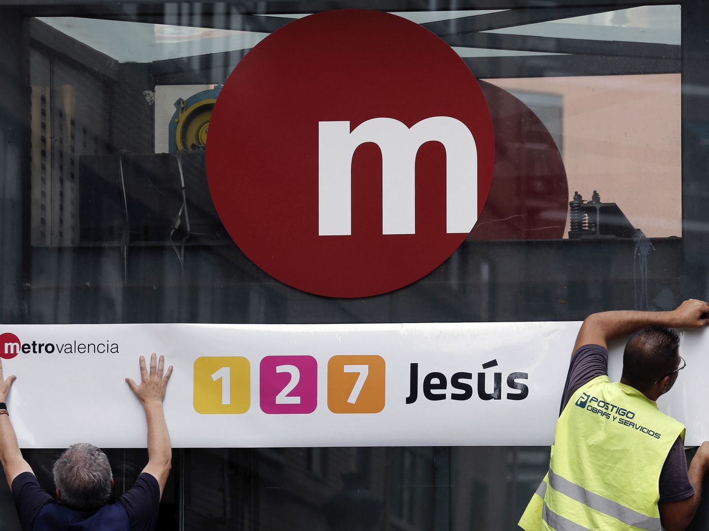 Operarios reponen el nombre de la estación donde se produjo el accidente, Jesús, que el Partido Popular cambió tras el siniestro. (EFE)