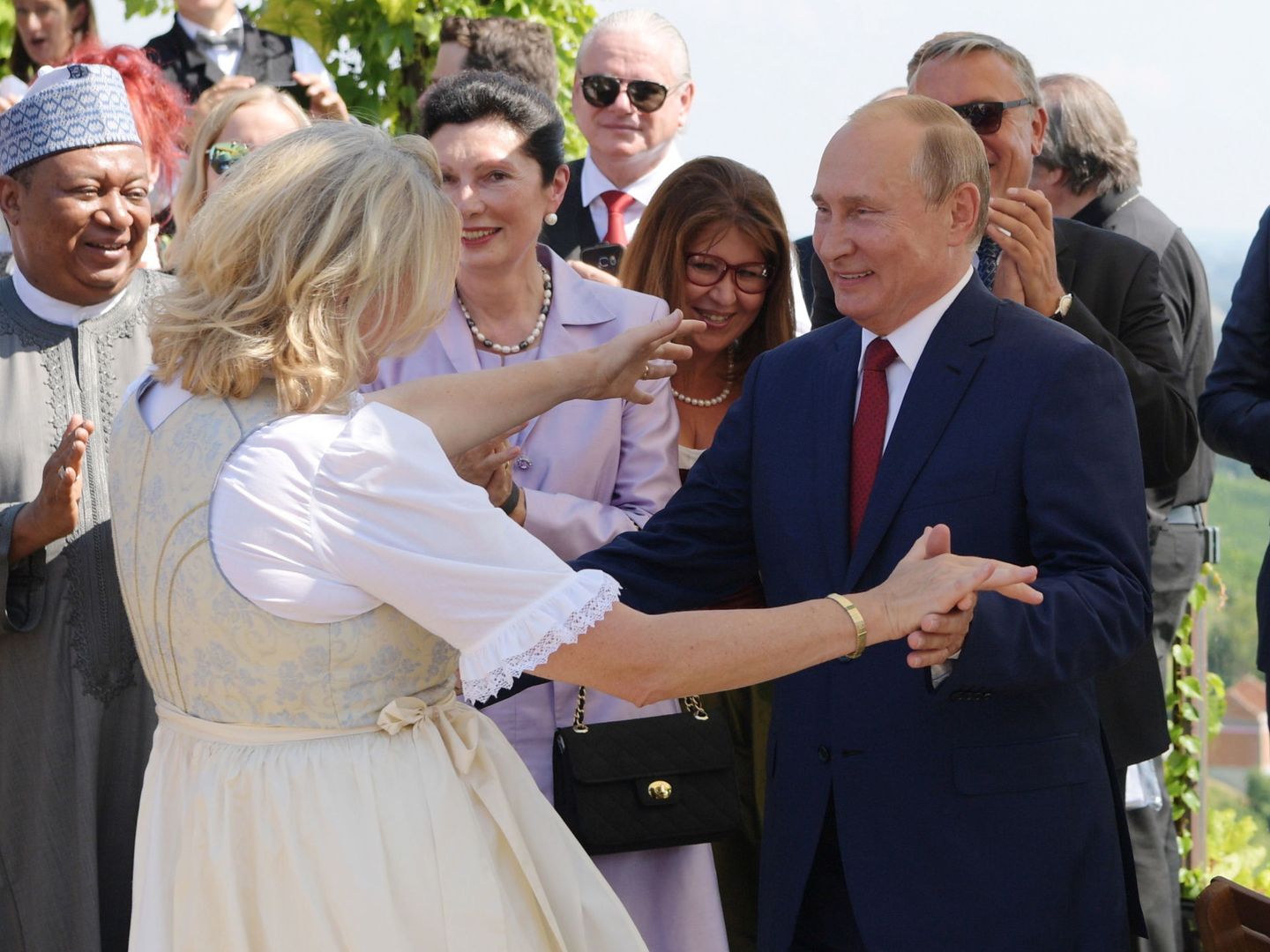 Putin bailando con la ministra de exteriores austriaca durante su boda, una invitación que ha levantado recelos. (Reuters)
