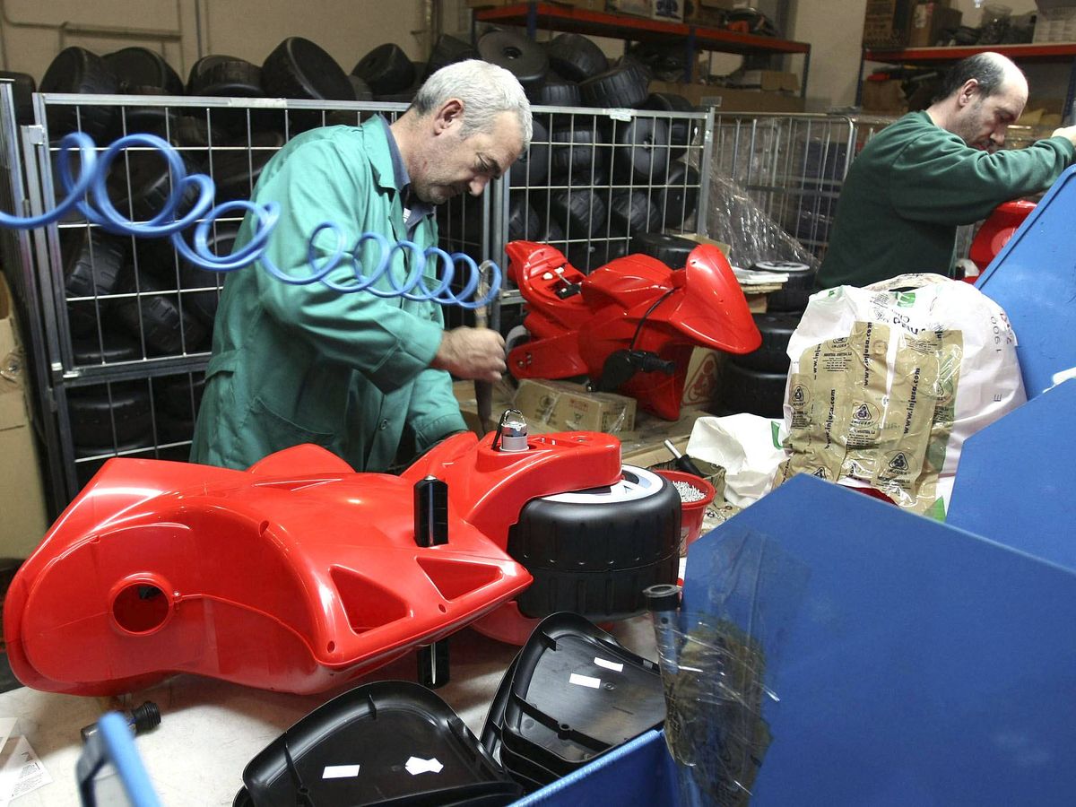 Foto: Dos trabajadores montan una moto de juguete en una empresa de Ibi. (EFE/Morell)