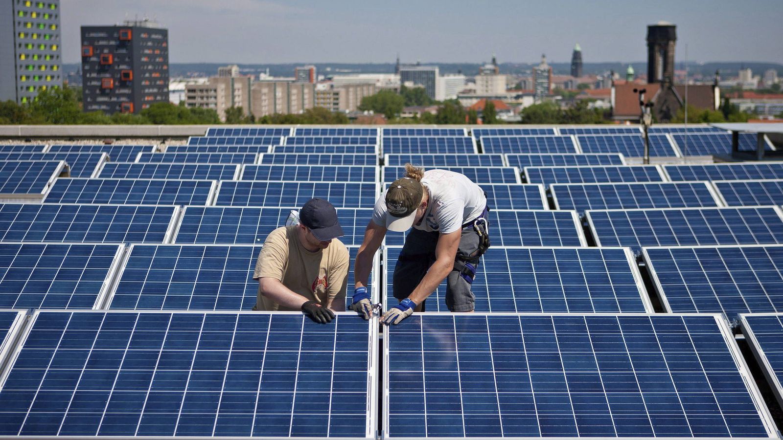 Foto: Dos operarios, instalando un panel solar. (EFE)