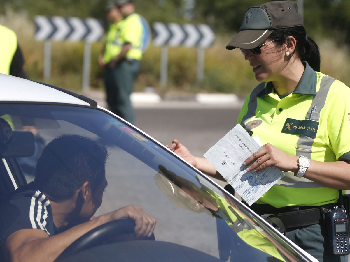Foto: Agente de la Agrupación de Tráfico de la Guardia Civil realizando un control rutinario de documentación. (EFE)