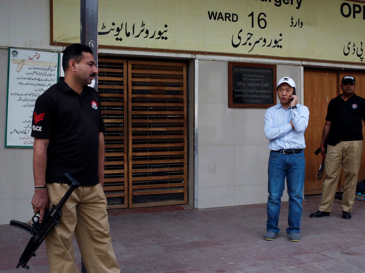 Policías custodian a un trabajador chino tras el asesinato de un compatriota en Karachi, el 5 de febrero de 2018. (Reuters)