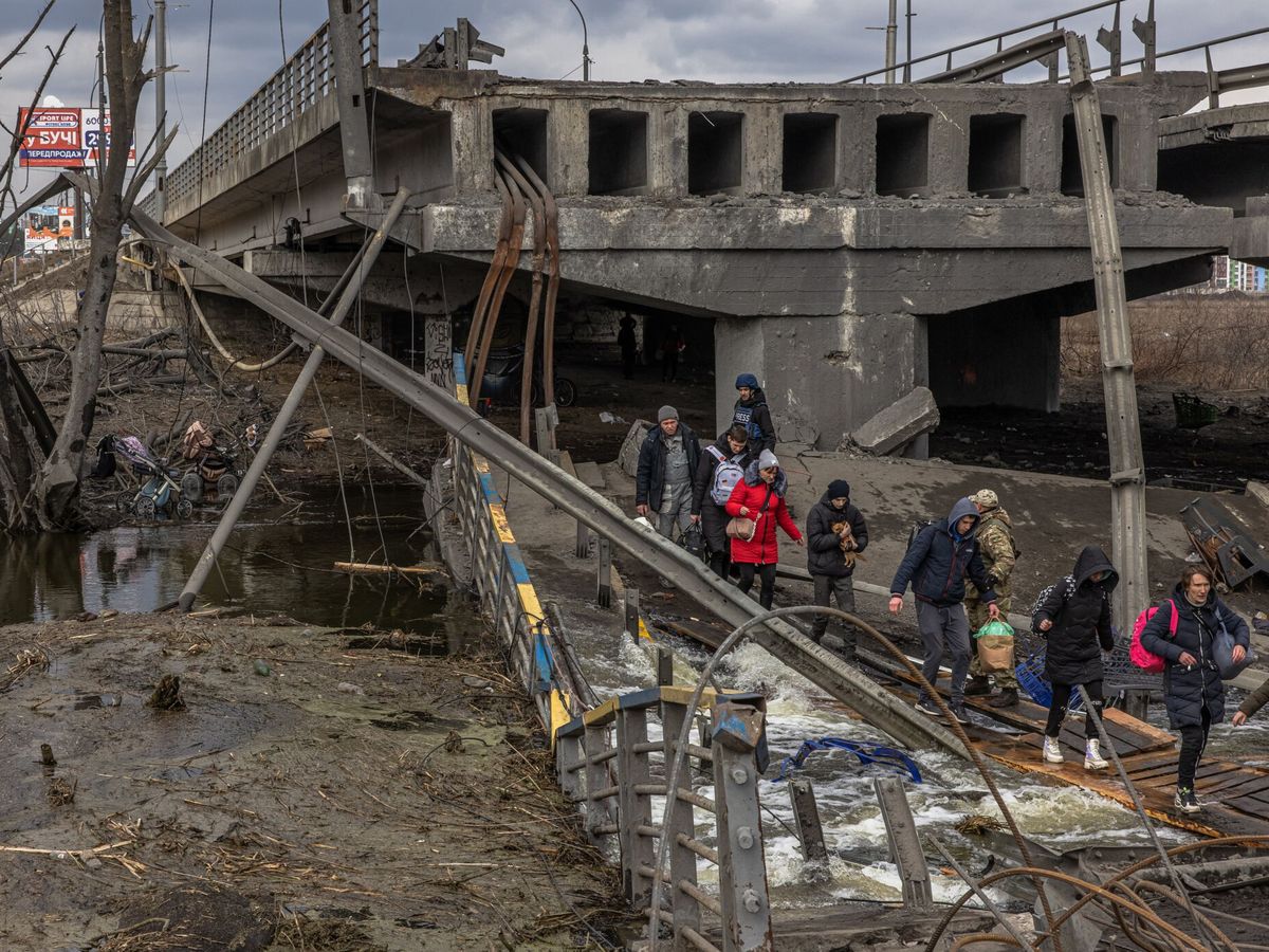 Foto: Los residentes cruzan el puente destruido mientras huyen de la ciudad de Irpin, en la región de Kiev. (EFE/EPA/Roman Pilipey)  