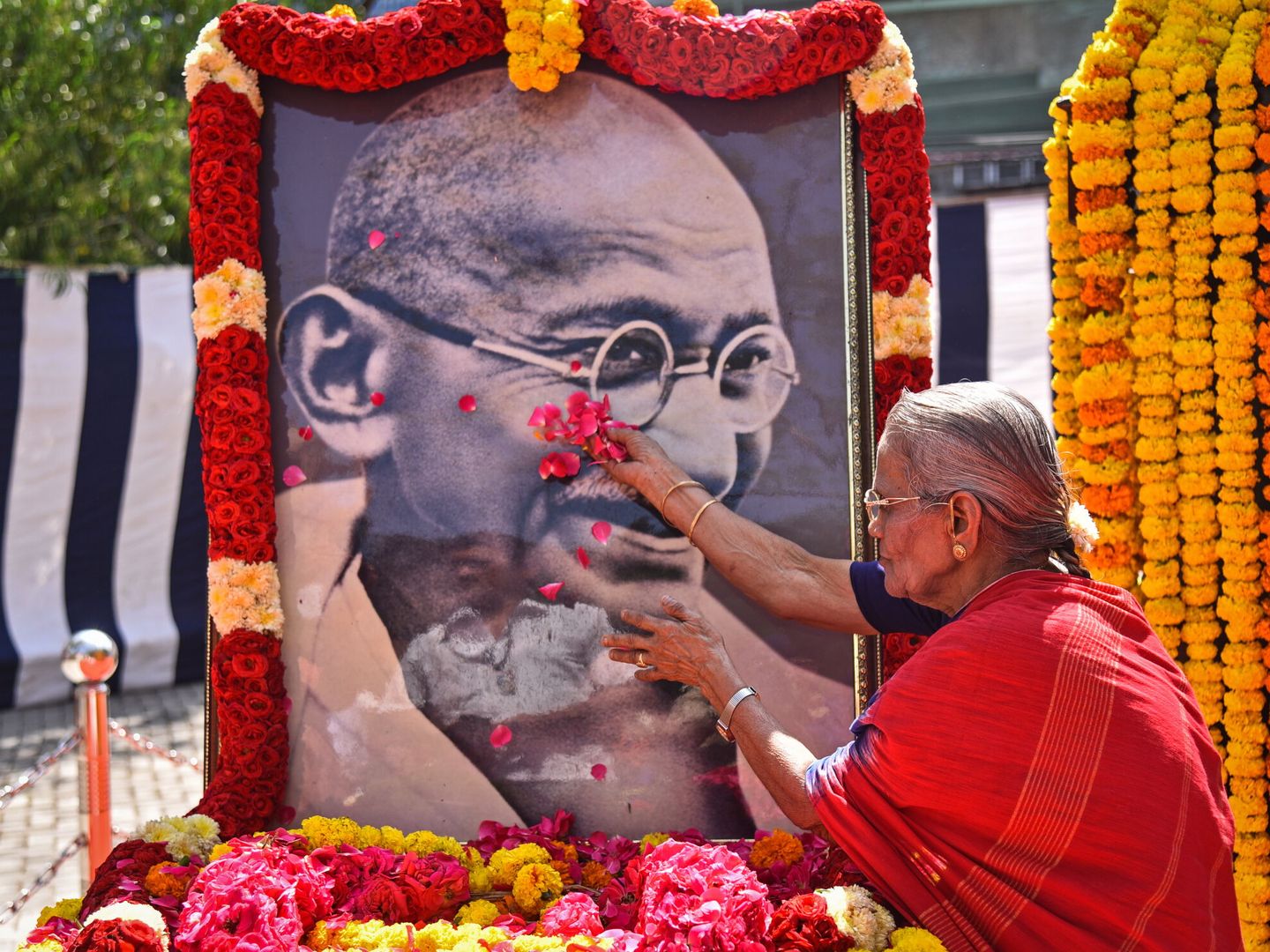 Una mujer rinde un homenaje floral a un retrato de Mohandas Karamchand Gandhi para conmemorar el 154º aniversario de su nacimiento en el Museo Egmore, Chennai, India (EFE  Idrees Mohammed)