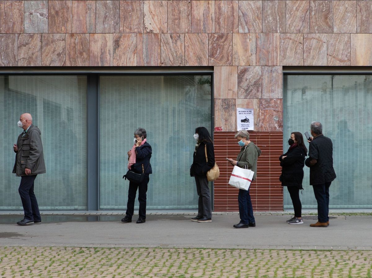 Foto: Numerosas personas hacen cola para vacunarse contra el covid en el Campus del Raval de la Universitat de Barcelona. (EFE) 