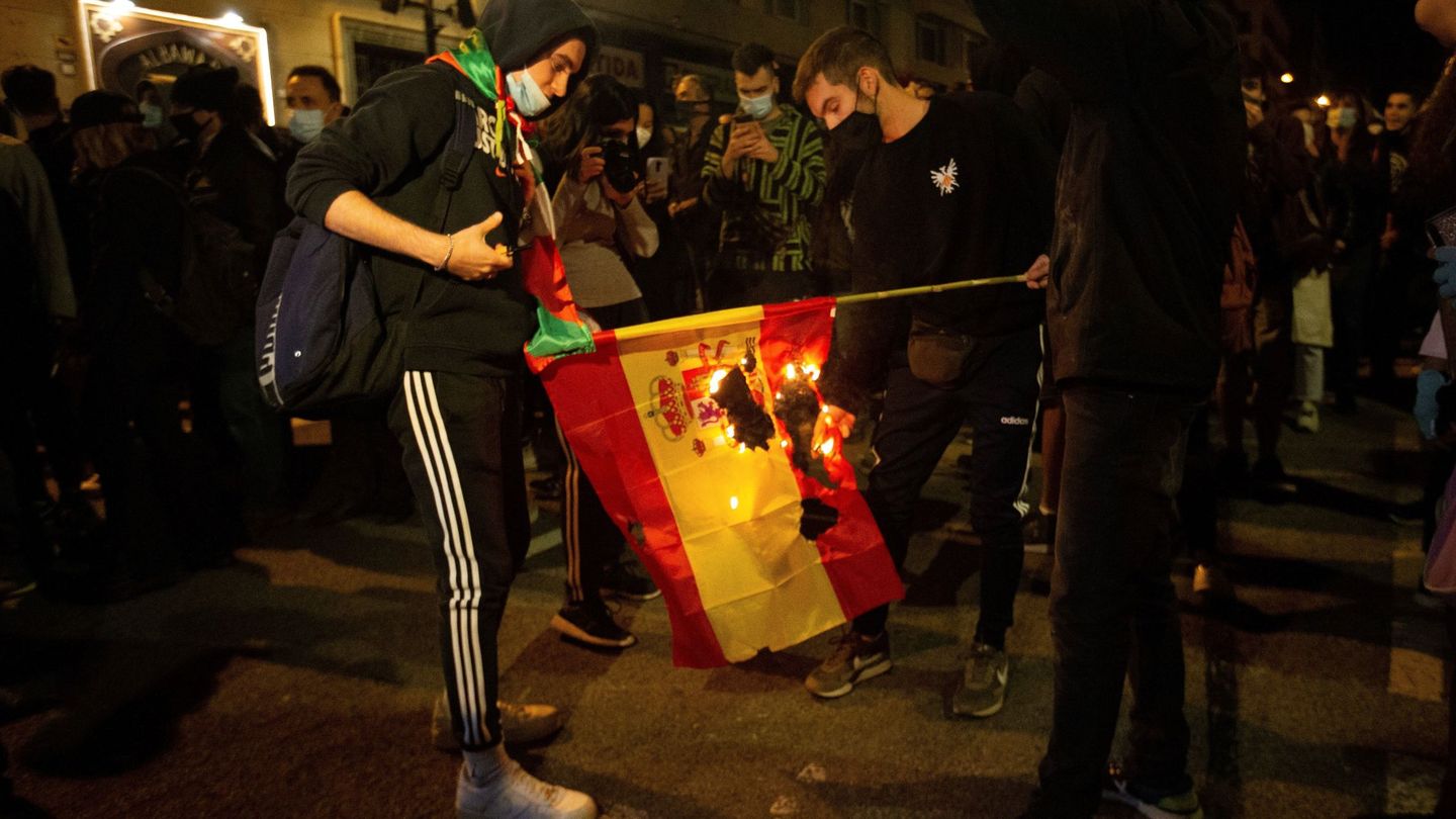 Varias personas queman banderas españolas durante una protesta en Barcelona. (EFE)
