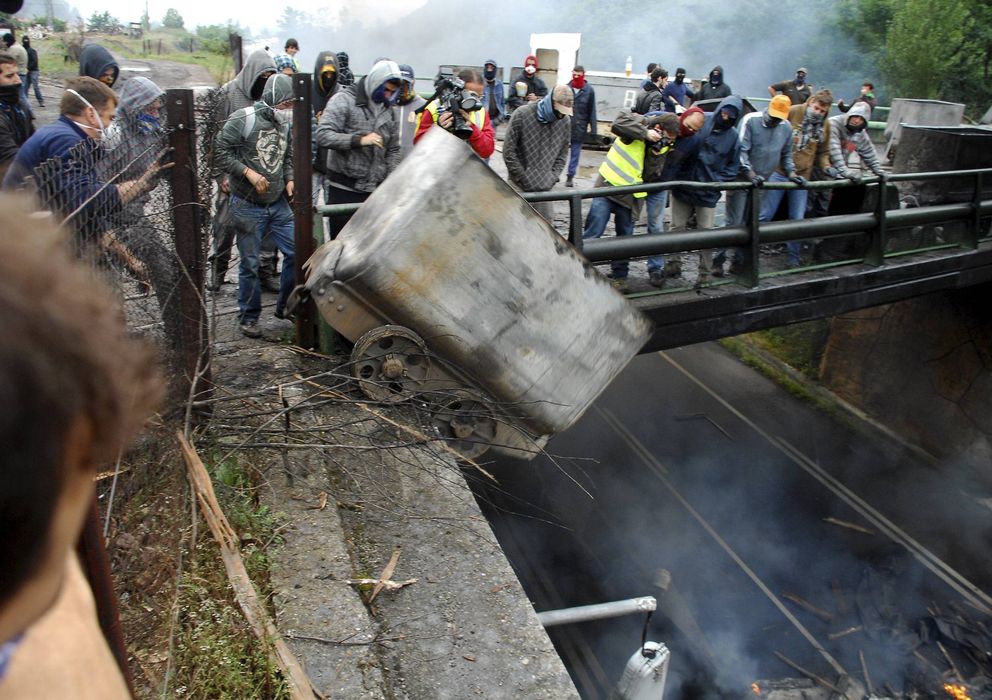 Foto: Un grupo de mineros lanza desde un puente a la carretera contenedores incendiados, en las inmediaciones del pozo Barredo, de Hunosa.