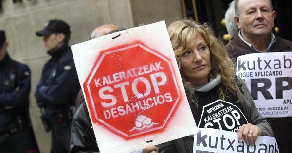 Foto: Miembros de Kaleratzeak Stop Desahucios e IRPH-STOP participan en una concentración frente a la sede de Kutxabank en San Sebastián. (EFE)