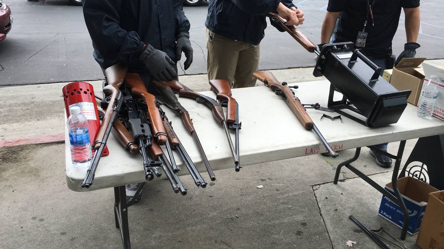 Armas entregadas voluntariamente que los agentes clasifican en una mesa (Foto: Eva Catalán).