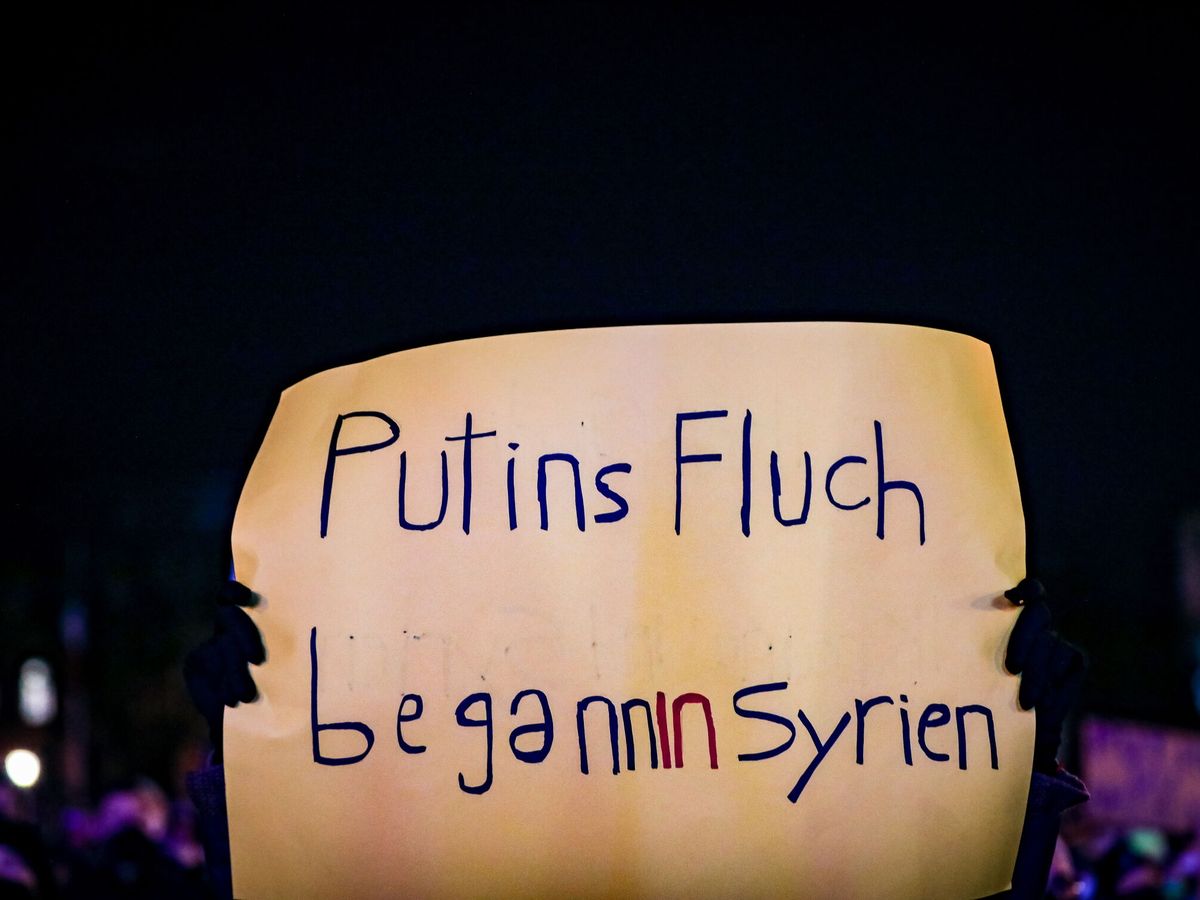 Foto: Un cartel en una manifestación en Alemania dice 'La maldición de Putin empezó en Siria'. (EFE/ Leonhard Simon)