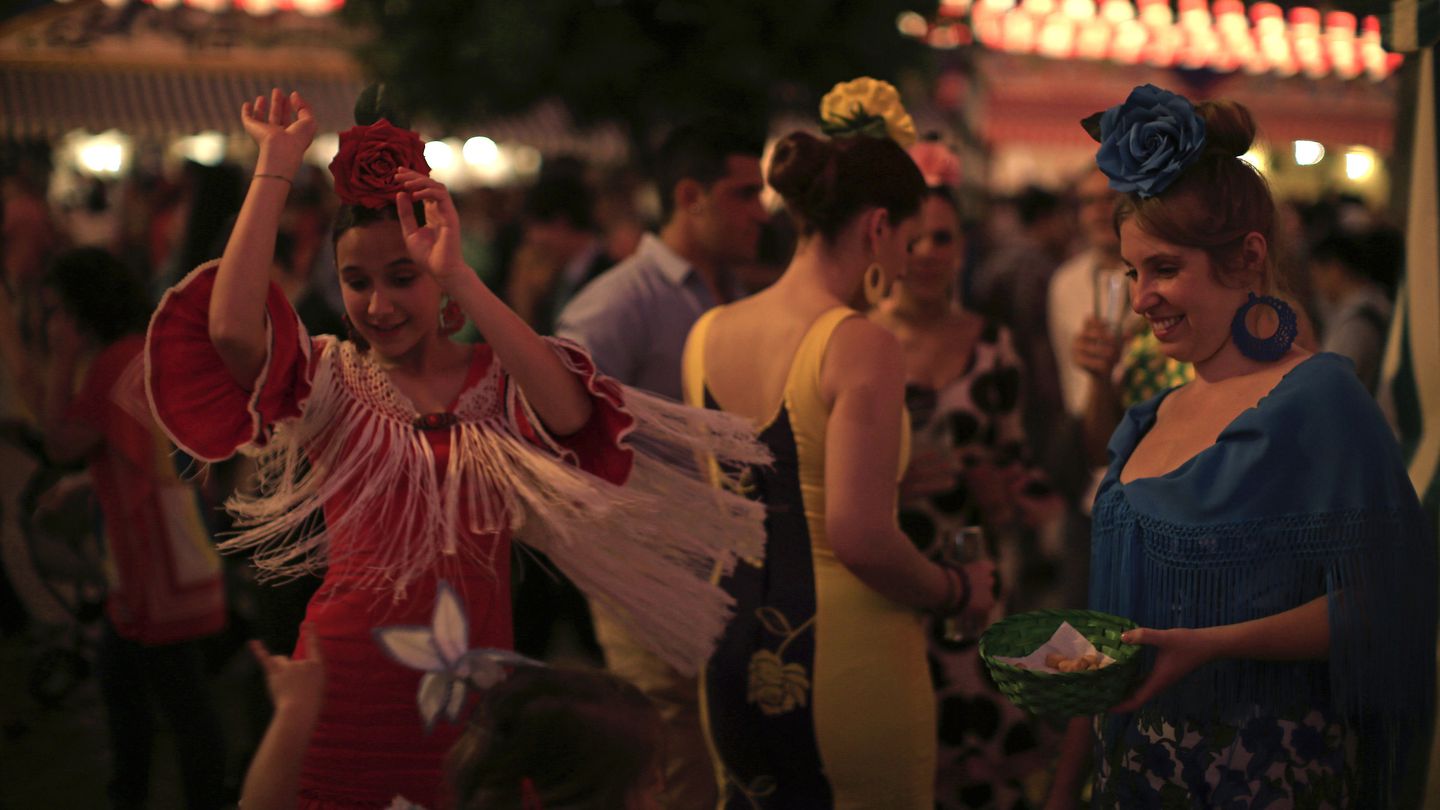 Mujeres bailando en la Feria de Abril de Sevilla en 2013 de noche (Reuters)