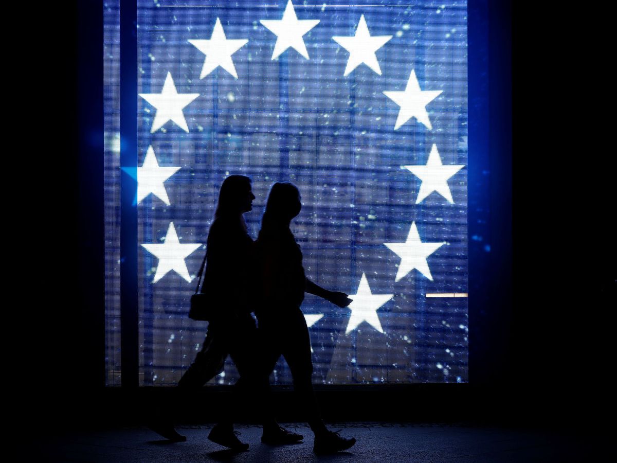 Foto: Dos peatones caminan frente a una bandera de la Unión Europea en Berín. (Reuters)