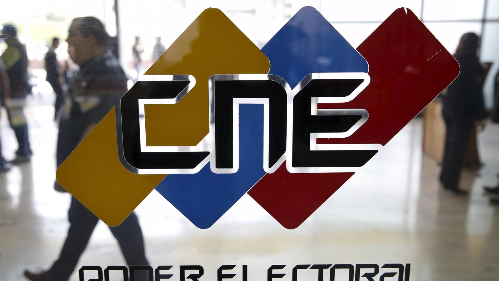 Foto: Venezolanos pasan ante un logo del Consejo Nacional Electoral, en su sede en Caracas, el 2 de diciembre de 2015 (Reuters).