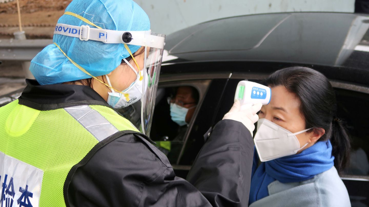 Un oficial de seguridad mide la temperatura de una ciudadana china. (Reuters)