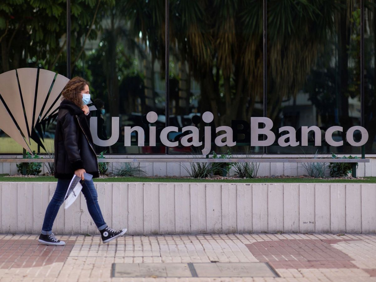 Foto: Una mujer pasa ante la sede del banco Unicaja en Málaga (EFE)