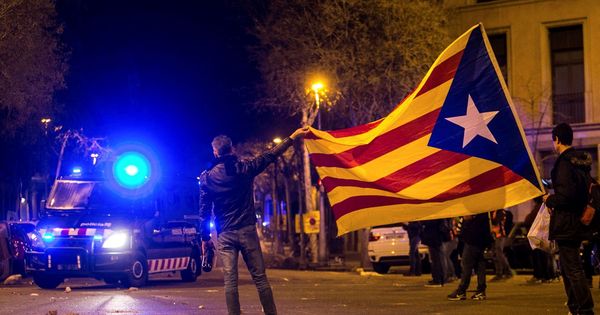 Foto: Manifestación convocada en los alrededores de la Delegación del Gobierno en Barcelona muestran una bandera independentista al paso de un vehículo de los Mossos d'Esquadra. (EFE)