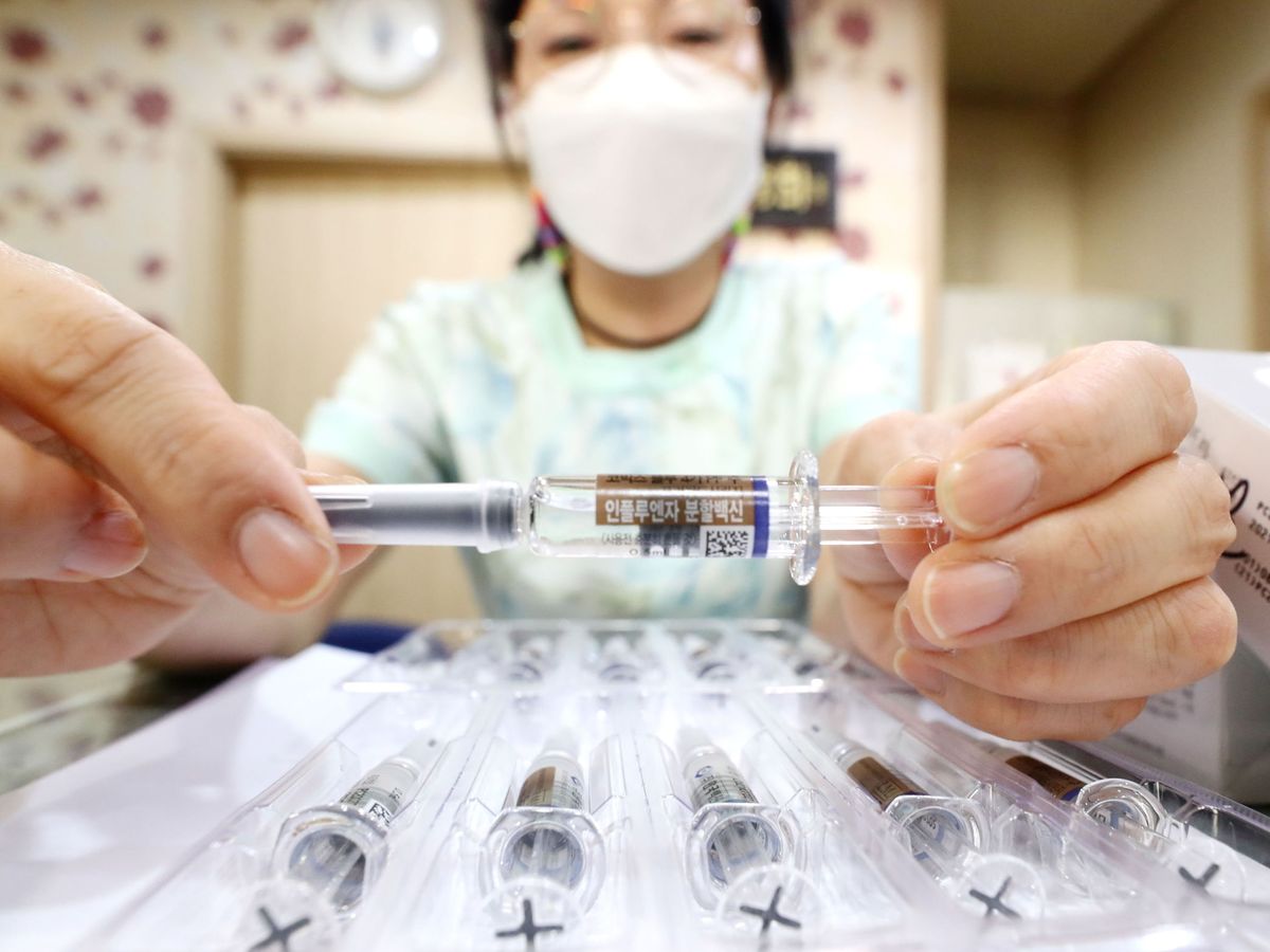 Foto: Una trabajadora sanitaria muestra a cámara una vacuna de la gripe en Seúl, Corea del Sur (EFE)