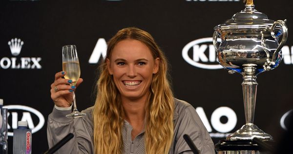 Foto: Wozniacki se presentó en la rueda de prensa con una copa de champán y el trofeo del Open de Australia. (EFE)
