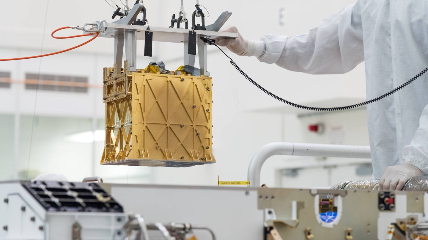 Ingenieros de la nasa metiendo a MOXIE en el 'rover'. (NASA)