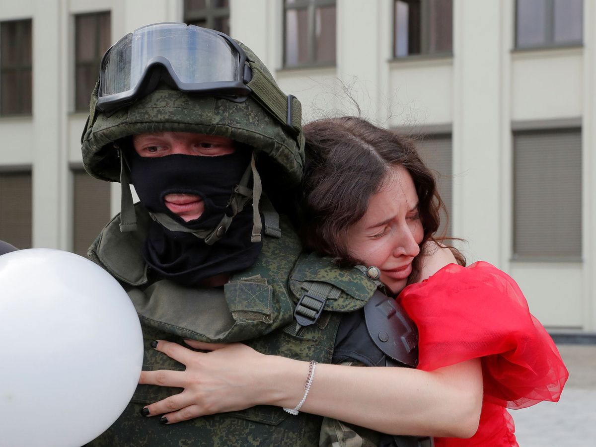 Foto: Una opositora abrazando a un soldado a las puertas del Parlamento bielorruso en Minsk. (Reuters)