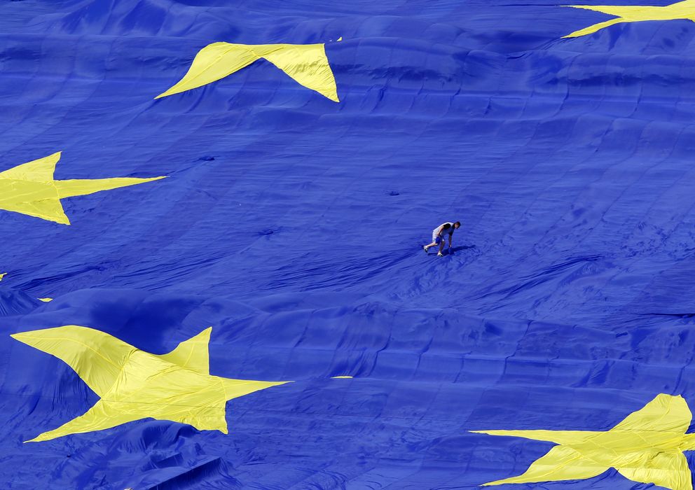 Foto: Un trabajador colabora en el despliegue de una inmensa bandera de la Unión Europea en el Día de la UE, en Bucarest (Reuters).