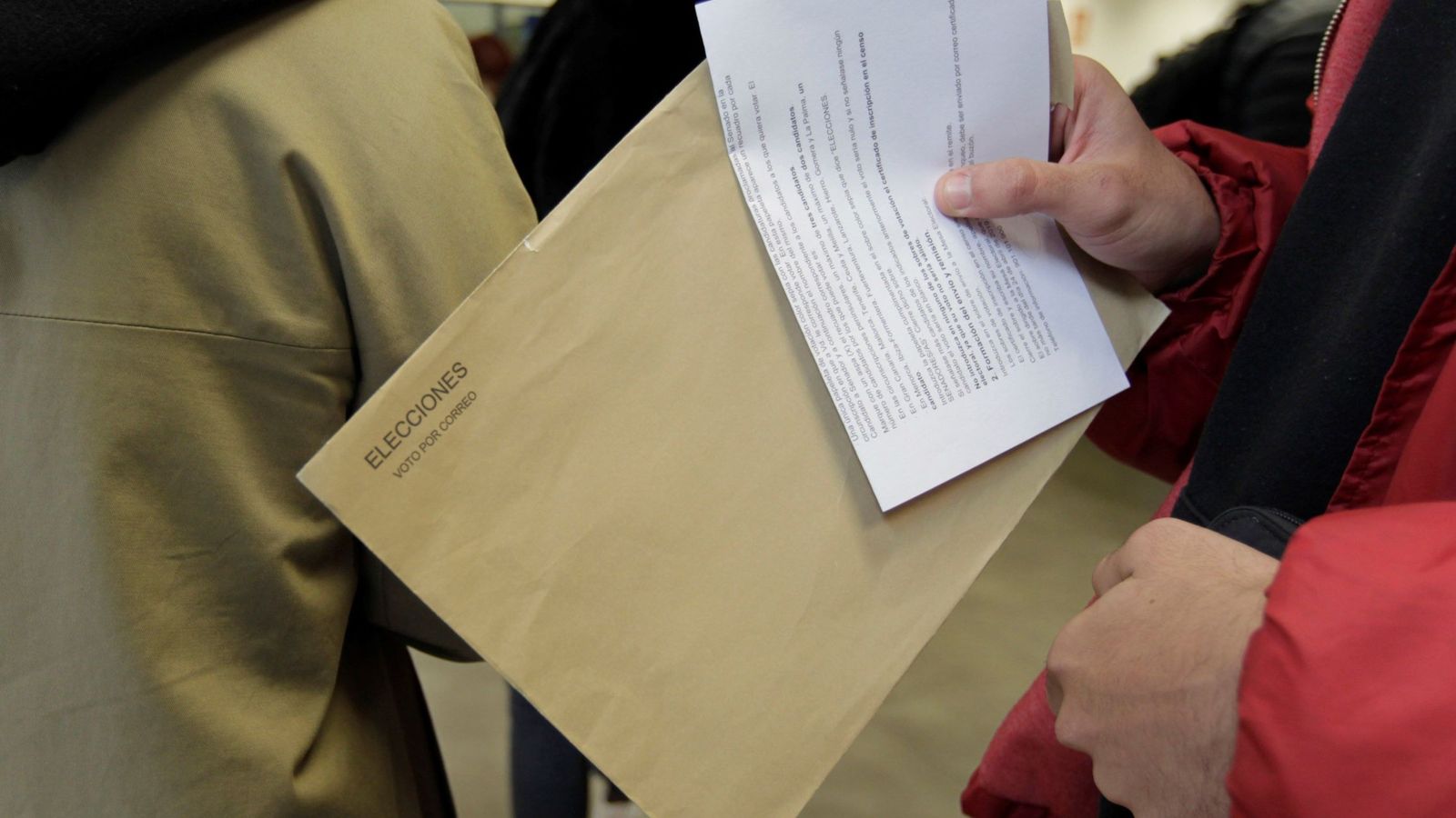 Foto: Un grupo de ciudadanos hace cola para votar por correo. (EFE)