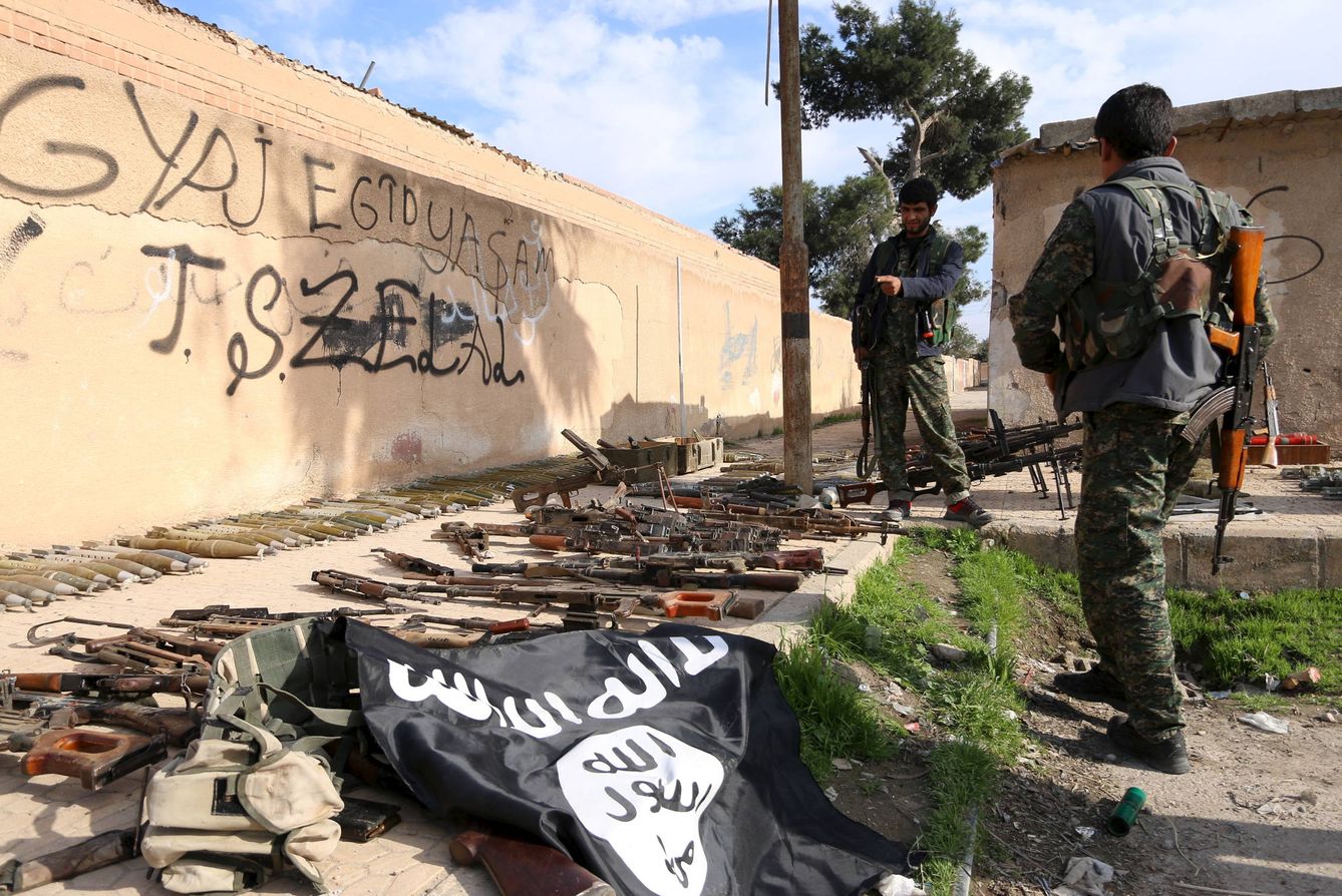 Combatientes kurdos inspeccionan armas y munición abandonada por el ISIS en Al Shadadi, en Siria (Reuters).