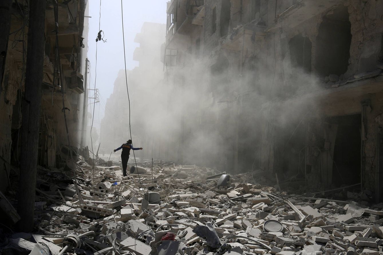 Foto: Un sirio camino sobre escombros de edificios dañados por los bombardeos en el barrio de al-Qaterji, en Alepo (Reuters). 