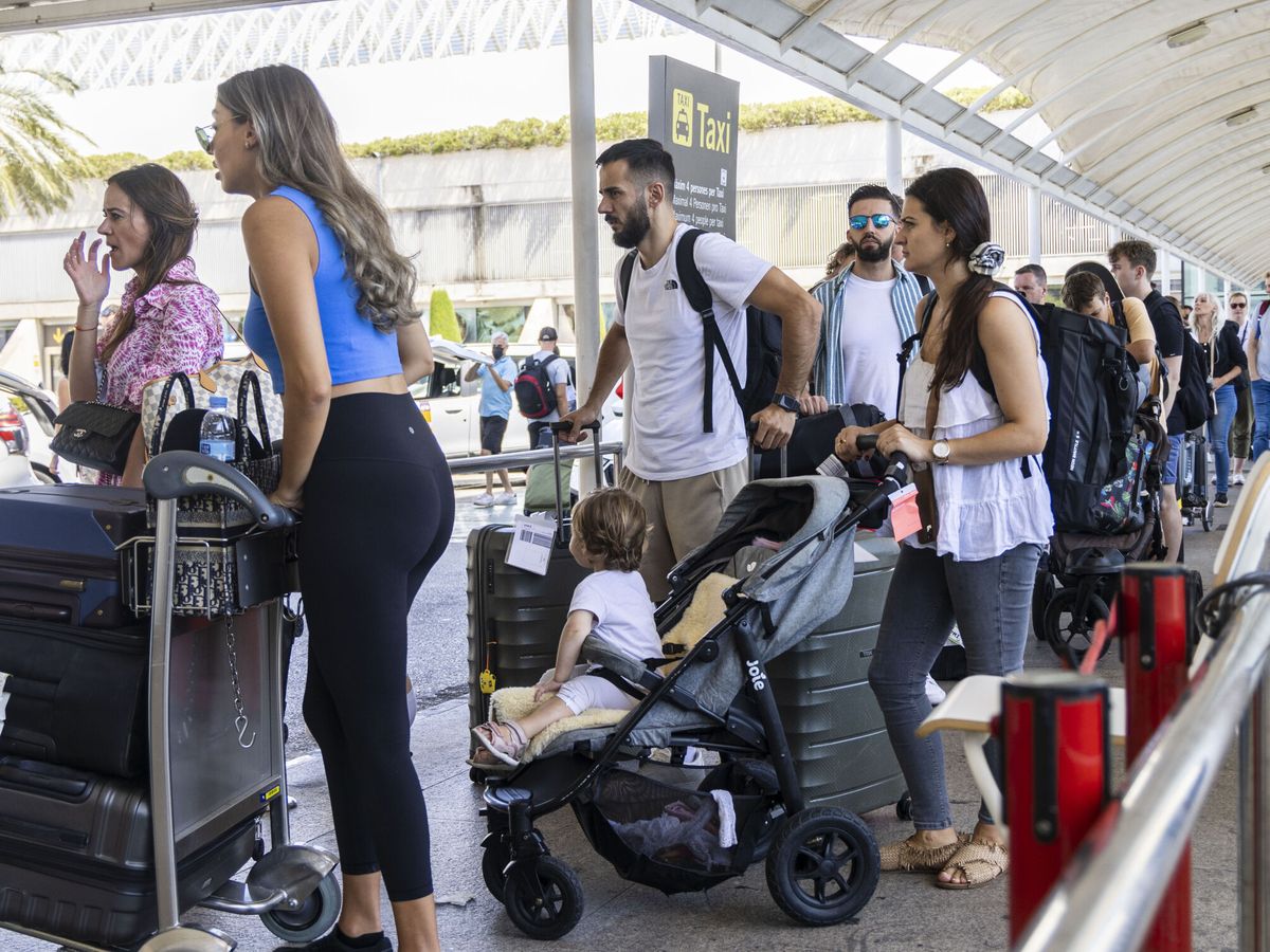 Foto: Largas colas de turistas que esperan un taxi en el aeropuerto. (EFE/Cati Cladera)