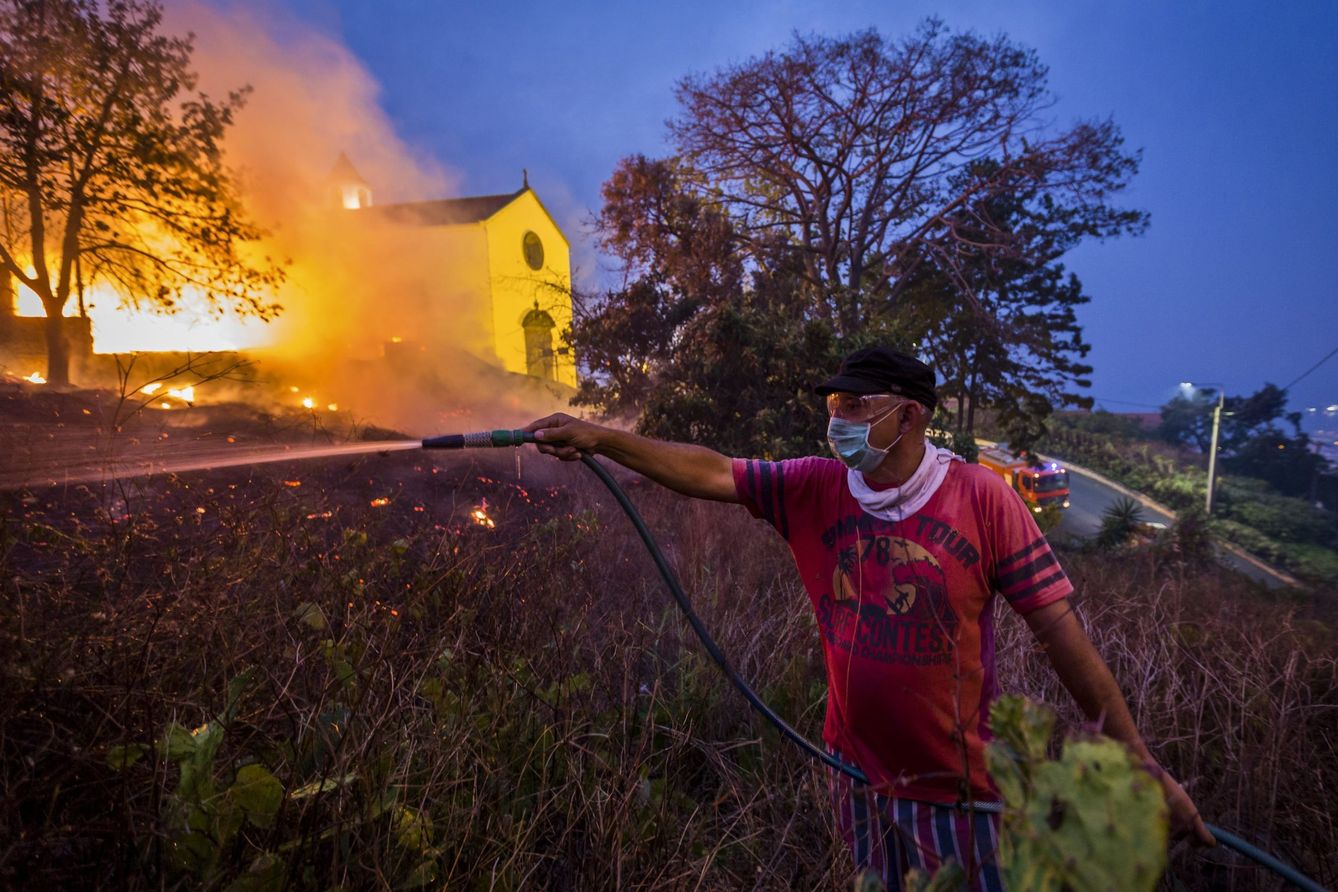 Foto: Un residente utiliza una manguera de jardín para ayudar en la extinción de un incendio en Funchal, isla de Madeira, el 10 de agosto (Reuters).