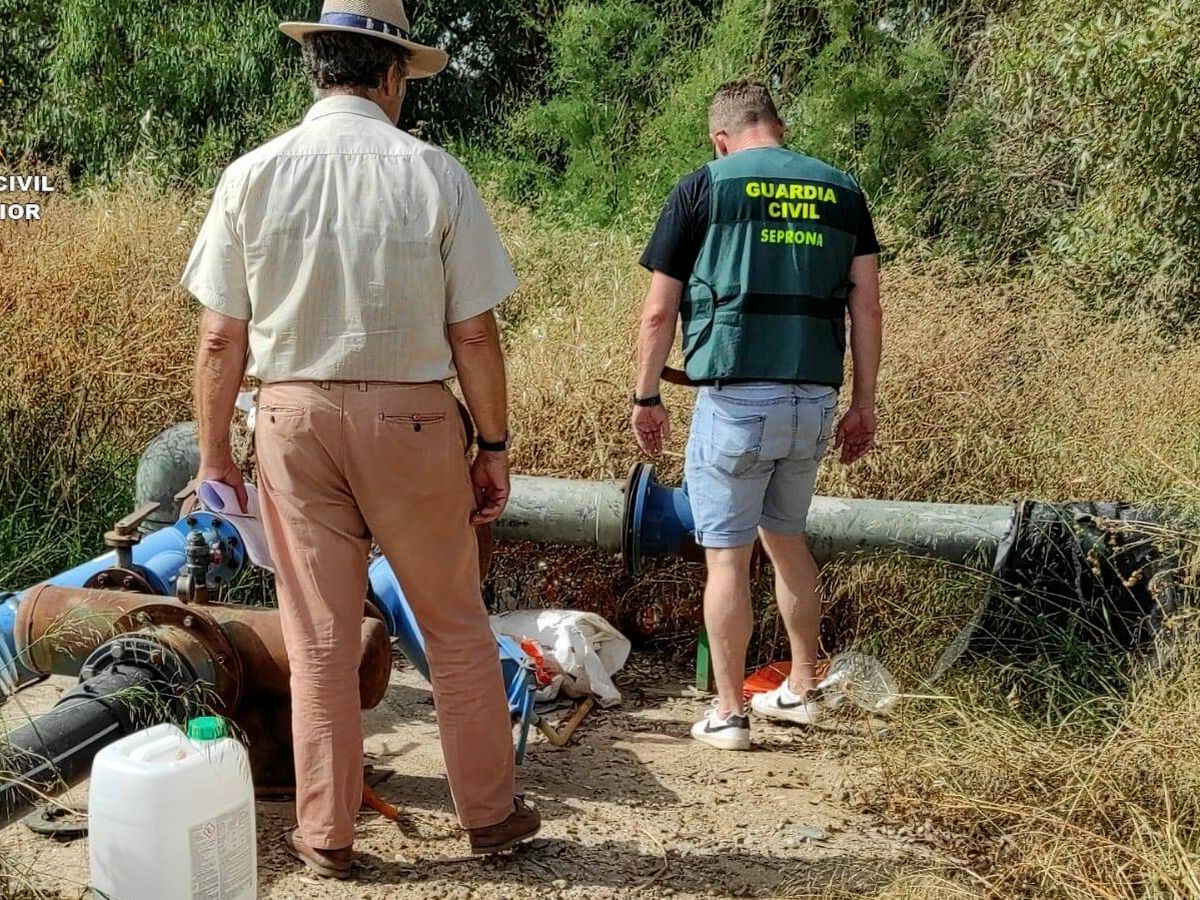 Foto: Un agente investiga una de las instalaciones para extraer agua del río. (Guardia Civil)