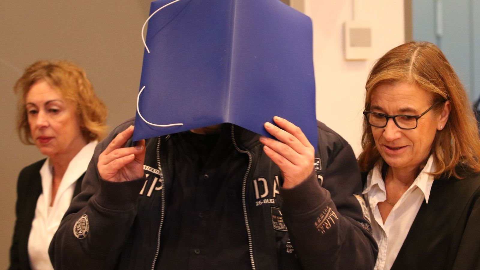 Foto: El enfermero Niels Högel se cubre el rostro al entrar en la sala de los juzgados de Oldemburgo en Alemania. (EFE)