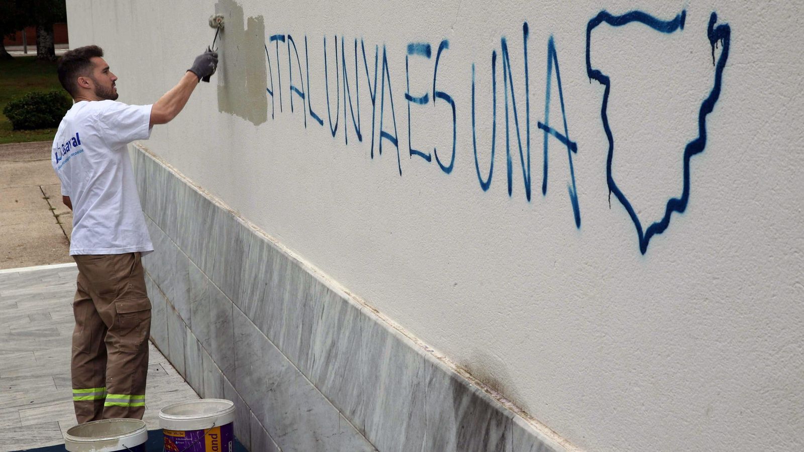 Foto: Un operario de la brigada de limpieza borran una pintada: "Cataluña es una", dice. (EFE)
