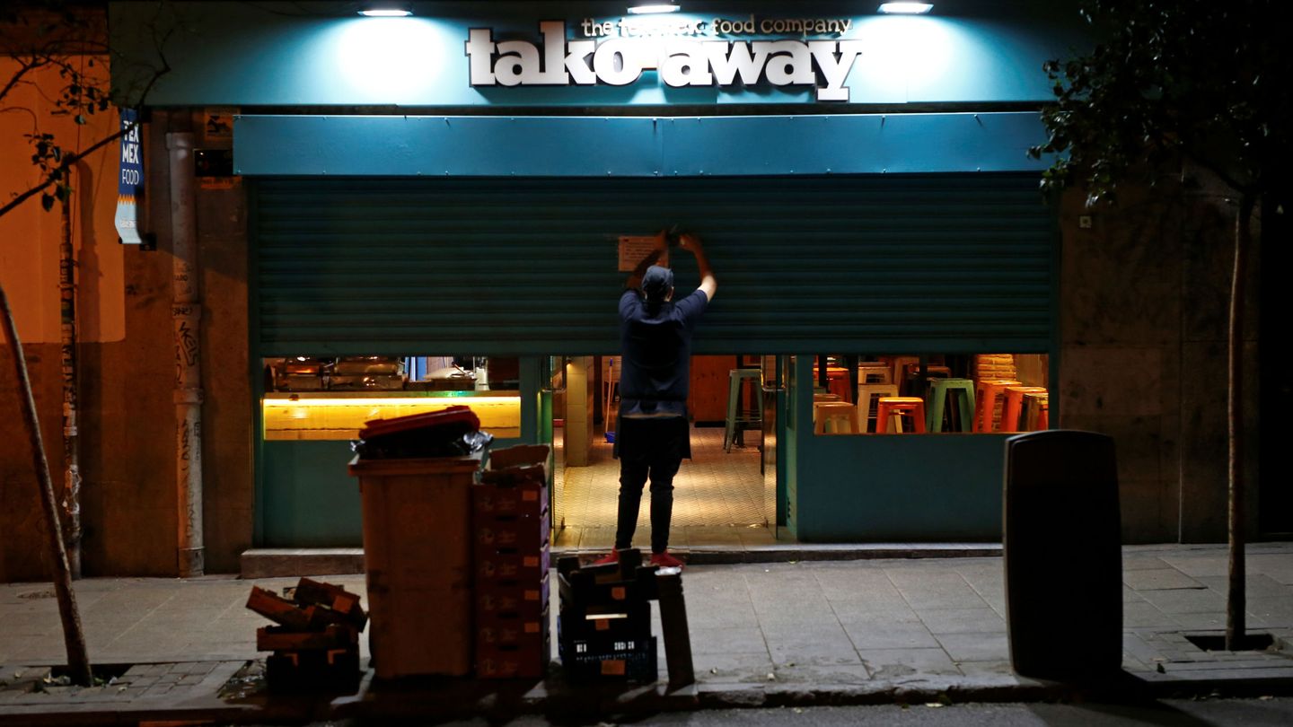 Un empleado echa el cierre de un restaurante en el centro. (Reuters)