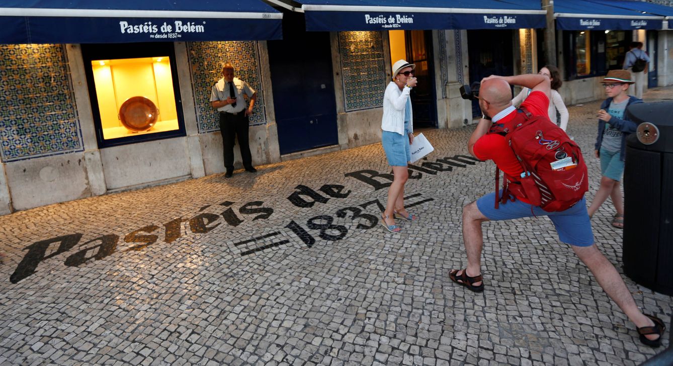 Un grupo de turistas se hace foto frente al famoso café Pastéis de Belem en Lisboa. (Reuters)