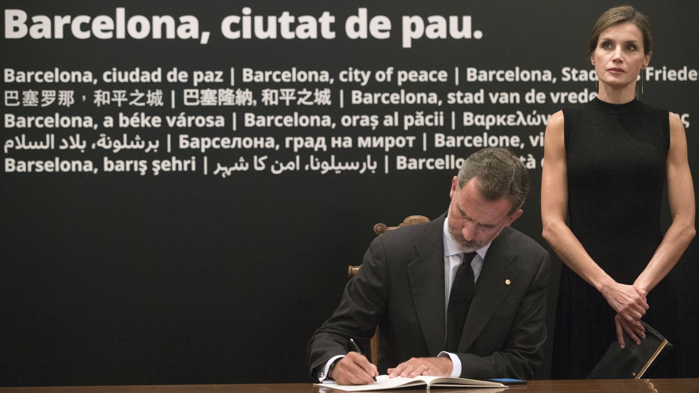 Los Reyes firman en el libro de condolencias en el Ayuntamiento de Barcelona. 
